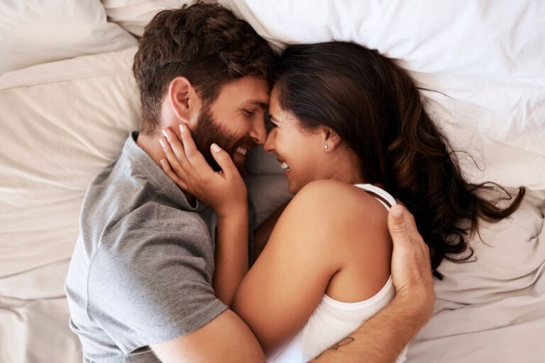 Glückliches Paar im Bett, zeigt Nähe und Verbundenheit in der Partnerschaft.