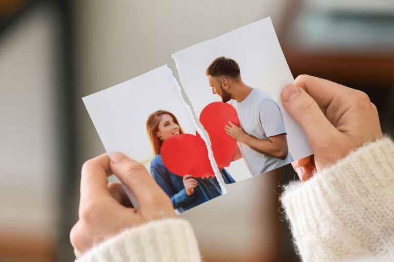 Mann und Frau halten zerrissenes Herzbild, Symbol für Beziehungsprobleme und Liebeswiederaufbau.