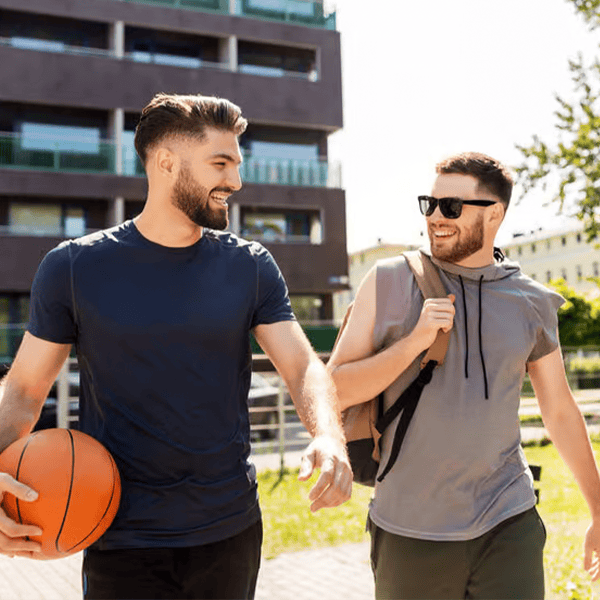 Zwei junge Männer beim Basketball im Park, freundschaftlich und sportlich.